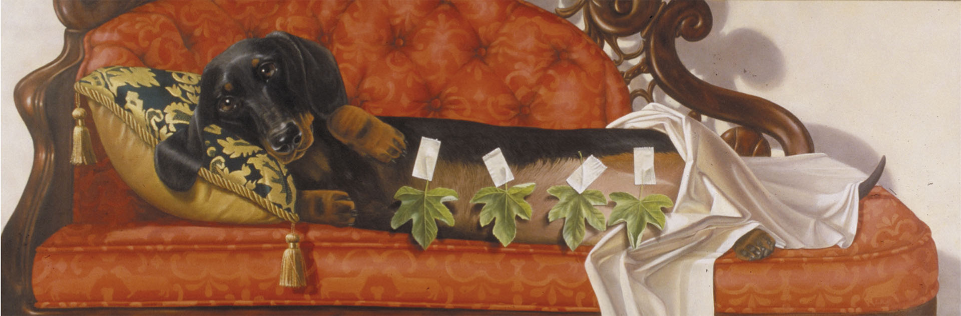 A 33.5in x 14.5in print by Lorena Pugh, depicting a black and brown daschund lounging coyly, paws tucked under her head, on a red couch. Four leaves are taped over her nipples, and a white cloth is draped over her bottom half. She rests her head on a blue and gold embroidered pillow.